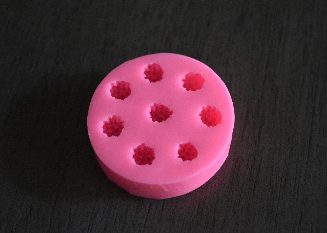 A top view of the black berry mold. The soap mold is pink.
