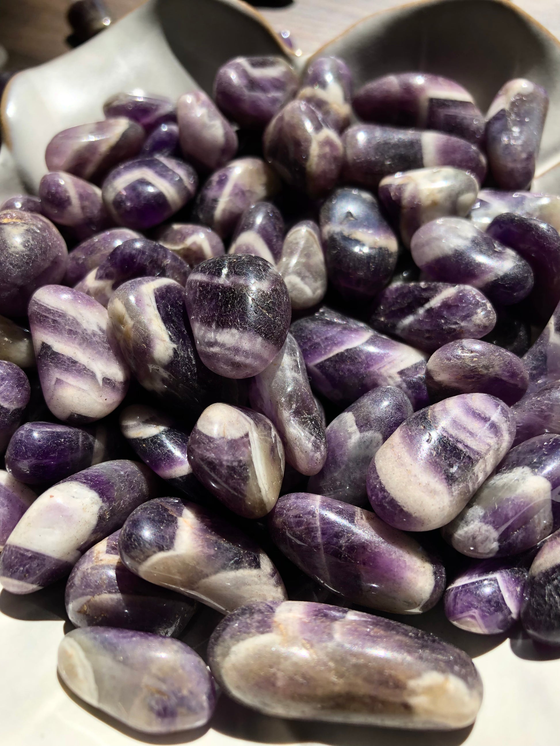 An up close picture of chevron banded amethyst stones. They are various hues of purple with swirls of white and cream colors.