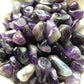 A close up picture of the tumbled amethysts sitting in a white bowl.