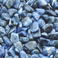 A top down view of an assortment of sodalite stones. The stones are various hues of blue with swirls of white on them.