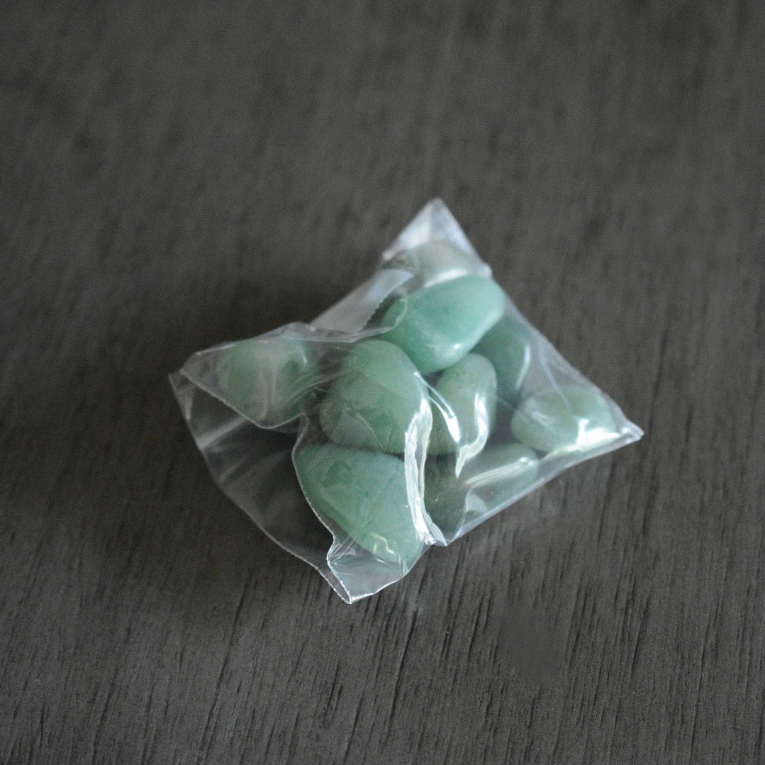 A packaged set of green aventurine tumbled stones in a plastic bag.