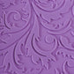 A close up view of the texture of the purple floral filigree mat.