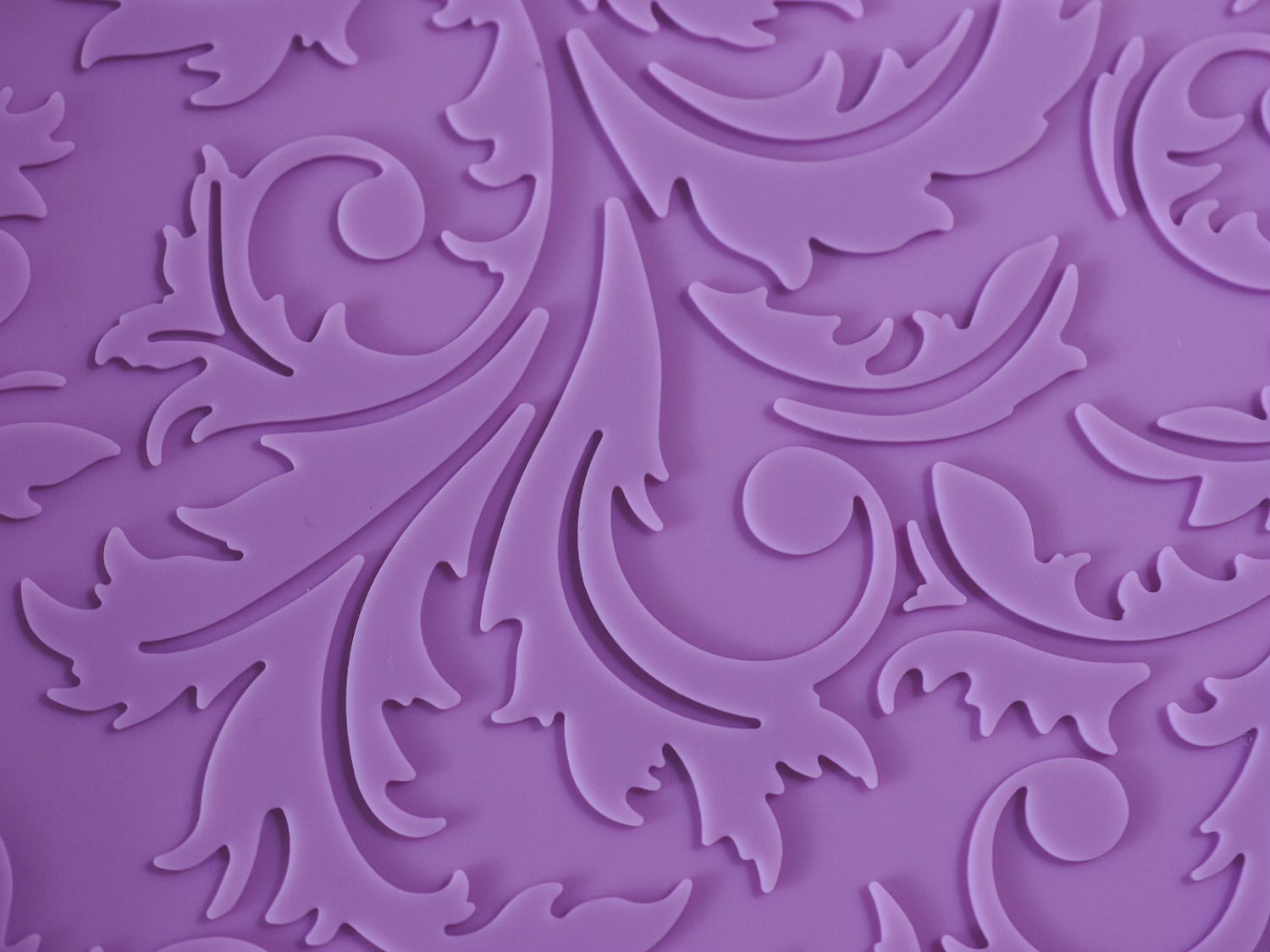 A close up view of the texture of the purple floral filigree mat.
