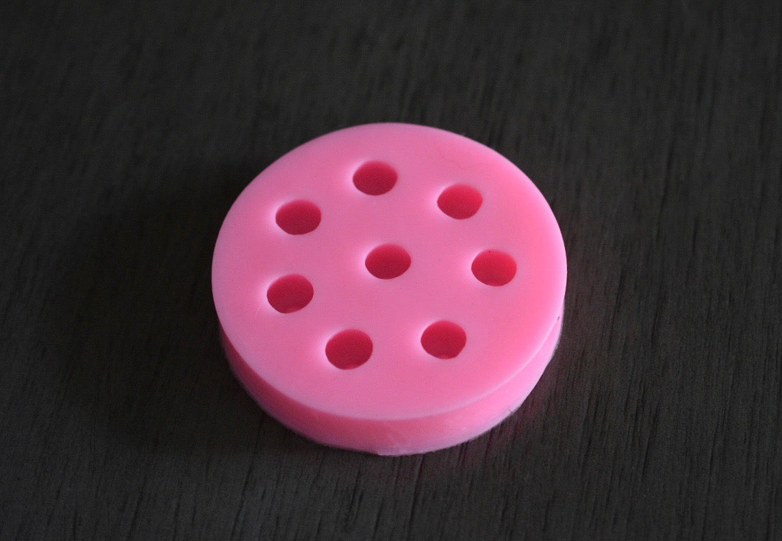 A top view of the blueberry mold on a wooden surface. The mold is pink.